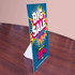 A promotional counter card featuring bright colours with a bold design, displaying a sale announcement.