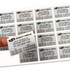 A hand holding a white sticker sheet featuring multiple rectangular stickers with black text and a logo.