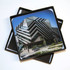 A set of full colour epoxy domed coasters featuring a modern building design, packaged in a black box with foam.