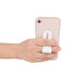 A hand holding a pink smartphone with a white push-pull phone stand attached, featuring a floral design.