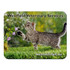 A fabric mouse mat featuring a playful grey tabby cat reaching for flowers, with a green grass background.