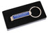A drink bottle opener in silver sits within a black gift box, featuring a branding logo on its side.