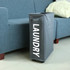 A grey laundry basket on wheels with handles, placed beside a sofa, featuring the word "LAUNDRY."