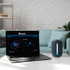 A blue outdoor waterproof Bluetooth speaker sits next to a laptop displaying a music player interface.