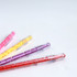 A set of colourful pens in pink, yellow, purple, and red, each featuring a maze design on the barrel.
