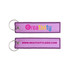 A purple woven key tag with a metal ring, featuring a logo and website on both sides.
