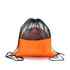 An orange drawstring mesh backpack with a black top, holding a basketball inside. It features a logo.