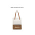 A convertible canvas backpack in white and brown, featuring a logo and leather-like straps. Zippered pocket at the front.
