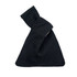 A black cotton wrist bag with a knotted top, featuring a simple design and a logo.