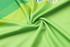A vibrant green micro mesh fabric featuring a subtle pattern, perfect for a long-sleeved polo shirt, with a logo present.