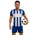 A man holds a soccer ball while wearing a blue and white striped athletic shirt with matching shorts.