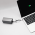 A silver charging cable connected to a laptop, with a visible battery charge indicator on the screen.