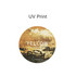 A round frosted metal coaster featuring a yellow abstract design with hints of earthy tones and a logo.