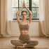 A model sits in a yoga pose, wearing a seamless thin-strap U-back crop bra tank and matching leggings in a tan colour.
