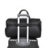 A black polyurethane duffle bag resting atop a silver suitcase, featuring a handle for easy transport.