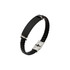 A braided black leather bracelet with a flat black centre piece and a silver clasp, featuring a logo.