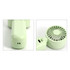 A foldable handheld fan in pale green, featuring a compact design with a visible logo and USB charging port.
