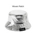 A silver bucket hat with a shiny, glittery finish and a woven patch on the side.