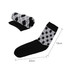 A pair of black and grey patterned socks, one rolled up, showcasing a woven design with a towel bottom.