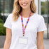 A retractable lanyard features a colourful, patterned strap with a clear ID holder, worn around a person’s neck.