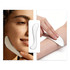 A silver facial Gua Sha massage tool is held against an arm, with a close-up of a smiling face nearby.