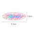 An oval iridescent hair clip in shades of pink and purple, featuring a logo, measuring 6.3cm by 1.9cm.