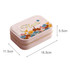A pink velvet jewellery box featuring floral embroidery, with a zip closure and internal compartment.