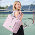 A lightweight pink tote bag is carried by a woman on a tennis court, featuring a logo and adjustable straps.
