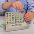 A game display featuring a light-coloured board with blue and green discs, showcasing a four in a row design.