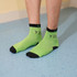 Bright green ankle socks with black accents, featuring a logo and custom pattern design. Ideal for casual wear.
