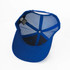 A blue trucker cap with a mesh interior and a black lining on the underside of the brim. It has a logo tag inside.