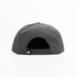 A grey cap viewed from the back, featuring a snapback closure and a logo on the side.