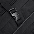 A close-up of a black backpack featuring a sturdy buckle and textured fabric. The design includes a zippered compartment.