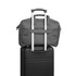 A grey laptop bag placed on top of a black suitcase, featuring a handle and zippers.