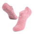 A pair of pink yoga socks featuring a crisscross design and textured grip on the soles.