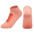 A pair of peach yoga socks with an open top design and textured grip on the soles.