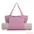 A pink canvas bag with long handles, displaying a rolled yoga mat in a neutral colour. The bag features a logo.