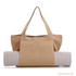A tan canvas bag with a yoga mat rolled up and secured inside. The bag has two handles and a logo.