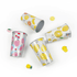 A set of four colourful, patterned cups featuring fruits like lemons, cherries, and peaches, with a shiny silver interior.