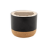 A cylindrical speaker in black with a cork base and a wooden top featuring cut-out slits.