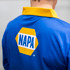A men's long sleeve fishing polo in blue with a yellow collar and a logo on the back.