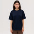 A navy blue T-shirt with a loose fit, featuring short sleeves and a round neckline, displayed on a model.