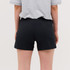 Black running shorts are displayed on a person, viewed from the back, with a grey t-shirt partially visible.