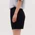 A pair of black shorts with an elastic waistband, displayed on the side with a neutral background.