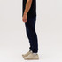 Navy track pants featured on a person, paired with beige sneakers, against a plain white background.