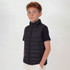 A black puffer vest for youth, featuring a zip closure and side pockets, worn over a black top.
