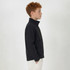 A youth black softshell jacket featuring a zippered front and side pockets. The jacket has a logo on it.