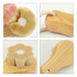 A flower-shaped facial cleansing brush with soft bristles and a wooden handle, featuring a hanging loop.