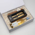 A gift box containing a wooden cheese board, a gold cheese knife, and a bottle of white wine.