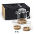 A glass tea pot with two glass cups, featuring a cork base, displayed beside a branded box.